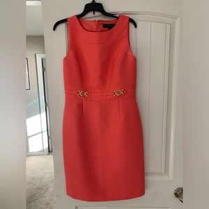 Coral lined dress with gold chains on front. Zipper in back.